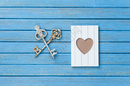 木制背景上的两把钥匙和相框背景图片