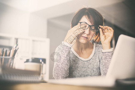 疲惫的中年妇女揉眼睛图片