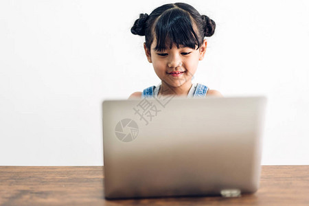 学童小女孩学习和坐着看笔记本电脑在家做作图片