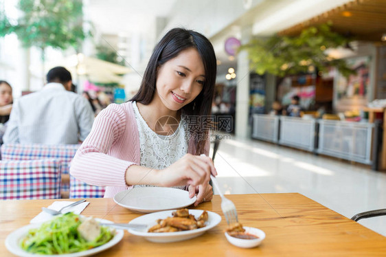 女人在餐厅享用她的饭菜图片