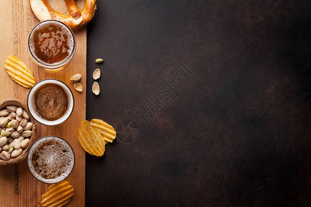 拉格啤酒和石桌上的零食带有复制空图片