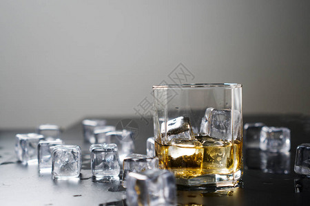 加冰块的玻璃威士忌深黑色背景图片
