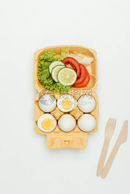 在白色隔离的蛋盘上的蔬菜和鸡蛋的顶部视图图片