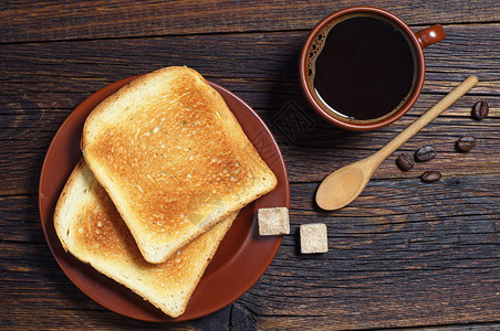 黑木制桌子上的烤面包和热咖图片