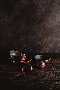 在质朴的木桌上近距离观察带有红洋葱的老式器皿图片