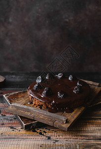 巧克力蛋糕在生锈木制餐桌上加玻璃图片