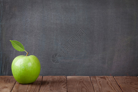 黑板前的教室桌上的苹果水使用背景图片