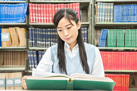 亚洲学生在大学图书馆阅读书本图片