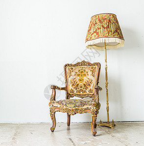 老式椅子和灯靠在白墙上图片