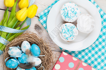 以蓝蛋和白蛋为巢黄郁金香和传统蛋糕图片