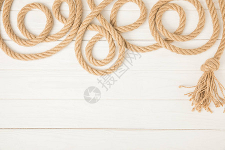 白色木质背景上棕色航海打结绳索的顶部视图图片