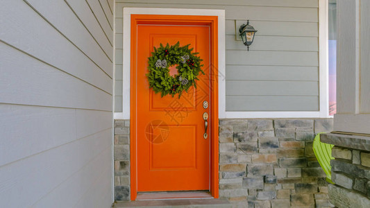 清晰的全景之家CleanPanoramaHome有欢迎花环挂在橙色前门上在房屋入口处也可以看到一个简单的门垫绿背景图片