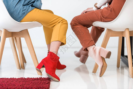 坐在椅子上的时装鞋子中时装妇女对时图片