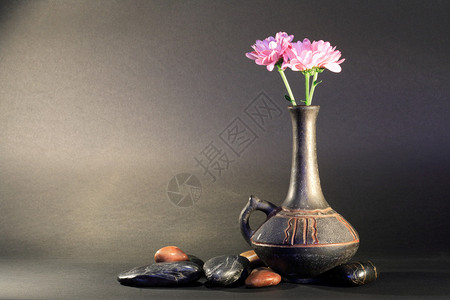 古老的陶瓷花瓶在黑暗背景的石头附近有美图片