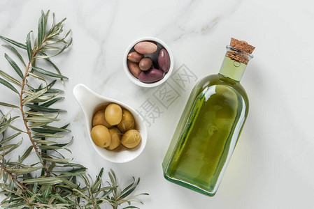 大理石表面碗中橄榄油和美味橄背景图片