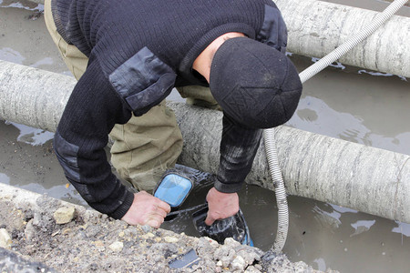 应急水务大队的一名工作人员手持水泵图片