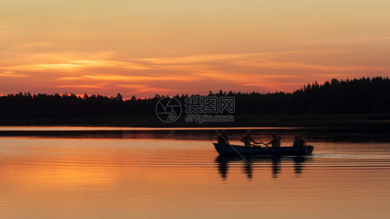 在金色日落时乘船和桨艇的轮廓森林图片