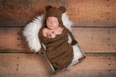 三周前刚出生的男婴戴棕色编毛帽图片