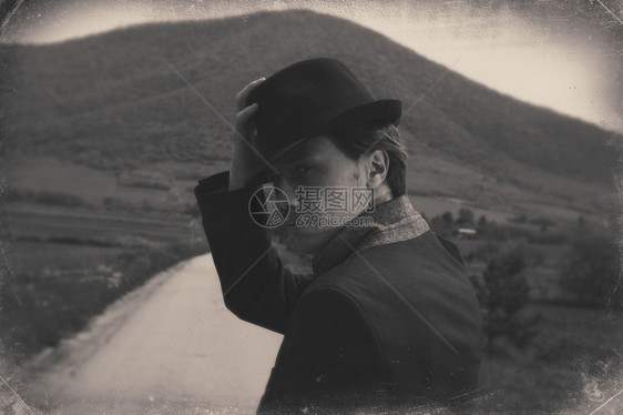 一位站在路上脱帽的绅士的古老照片黑白图片
