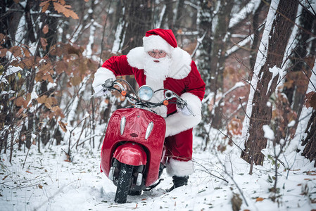 圣诞老人骑着红色的摩托车在雪路背景图片
