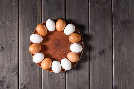 在庆祝复活节的木板上的棕色餐盘上鸡图片