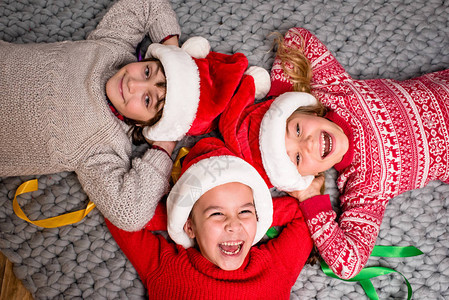 戴着圣诞老人帽子的快乐孩子躺在圆圈图片