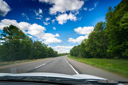 通过汽车挡风玻璃和天空白云看到的主图片