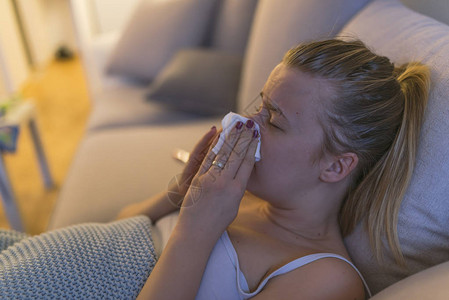 家里受流感困扰的年轻女在发烧时抽鼻图片