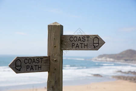 反对海和沙子背景的海岸路径标志图片