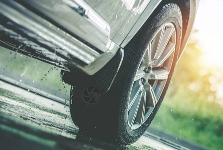 在雨中驾车在湿地的现代夏雨季轮胎关闭图片