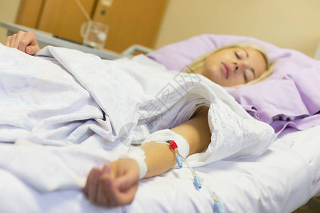 躺在医院床上在手术后恢复期间接受注射的受孕女病人请访问InfoFin图片