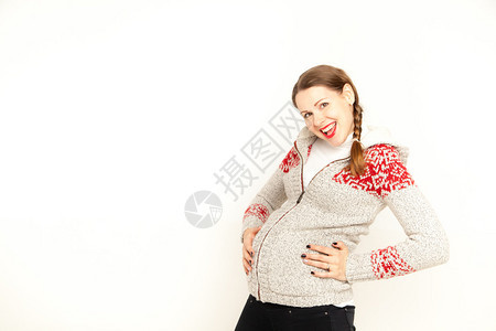 快乐的年轻孕妇穿着冬装在白色背景上跳舞Copy图片