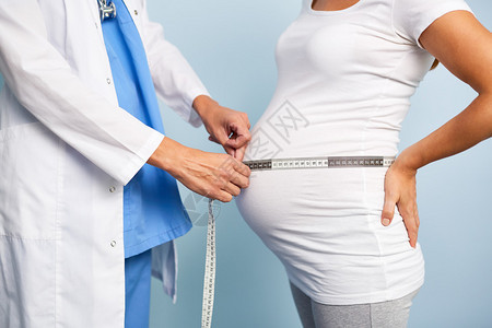 测量孕妇腹部大小的医生图片