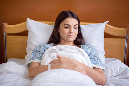 年轻女病人躺在医院床图片