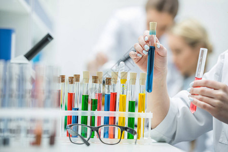 对实验室内带有试剂的女科学家持有测试管和试剂图片