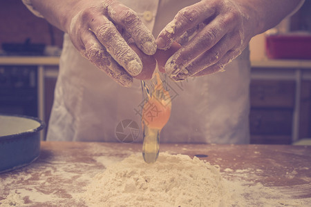 面包师切鸡蛋换面团的特写照图片