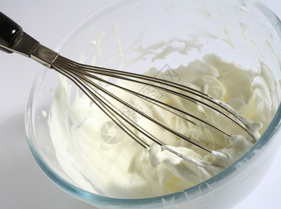 Whipping奶油双重奶油在玻璃碗中背景图片