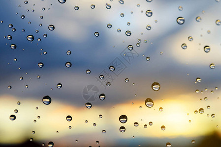 日落时下雨后水滴在窗玻璃上图片