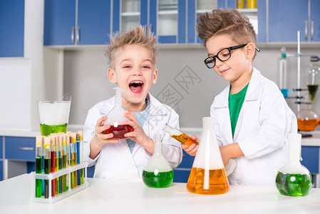 快乐的小男孩们在化学实验室里拿图片