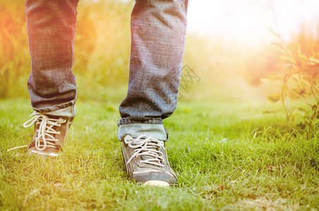 美丽的双脚走向阳光或在草地上或公园或田间跑步或早晨散步或锻炼时向日出或日落前进图片