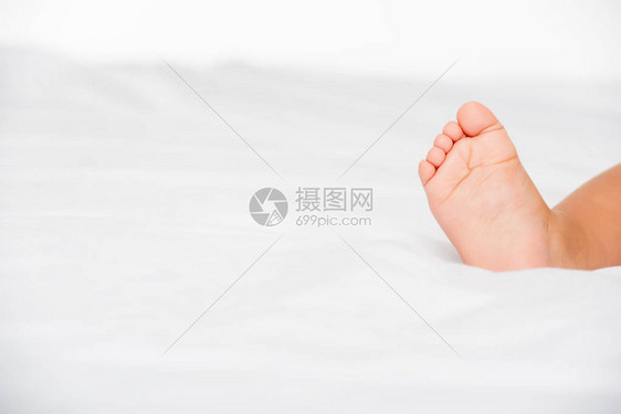 小婴儿脚在床上的裁剪照片图片