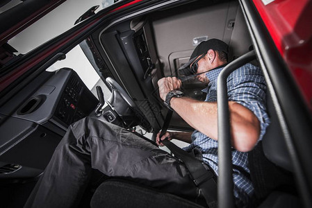 白种人卡车驾驶员使用安全带保障他的安全图片