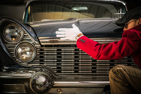 美国古典汽车评估专业工人在寻找车辆的损坏物高清图片