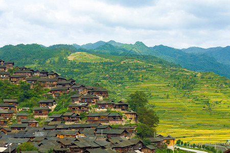 贵州XjiangMiao少数民族村传统木制房屋后面的高山角高山角背景图片