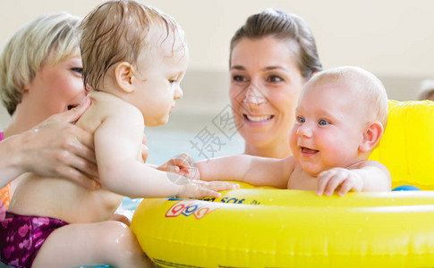 在婴儿游泳课上玩具游戏时妈和孩子们一图片
