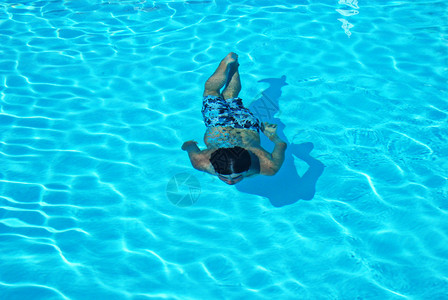 男孩在游泳池的水下游泳图片