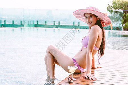 在游泳池中穿两件比基尼的女子暑假在度图片