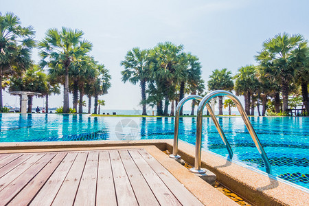 在酒店泳池度假胜地用棕榈树和海背景游泳池游泳池图片