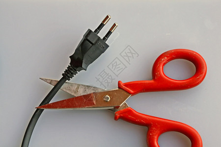 一把剪刀可以剪断黑色插头的电线图片