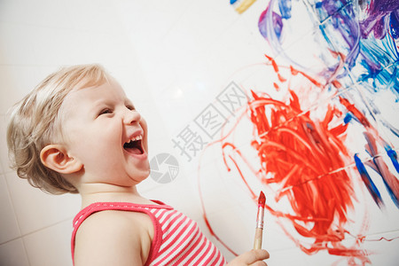 可爱的白人小男孩女在浴室墙上玩耍和绘画的肖像图片